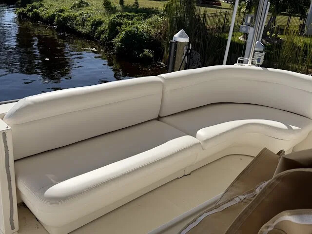 White curved bench seating on a boat docked beside a canal