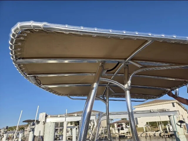 Tan canvas T-top on a stainless steel frame at a marina