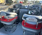 Gray and red upholstered helm seats with steering wheels on pontoon boats