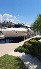 White yacht docked behind a waterfront home with landscaped steps