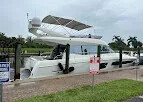 White flybridge yacht docked along a grassy canal