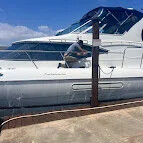 Technician working alongside a white yacht docked at a seawall
